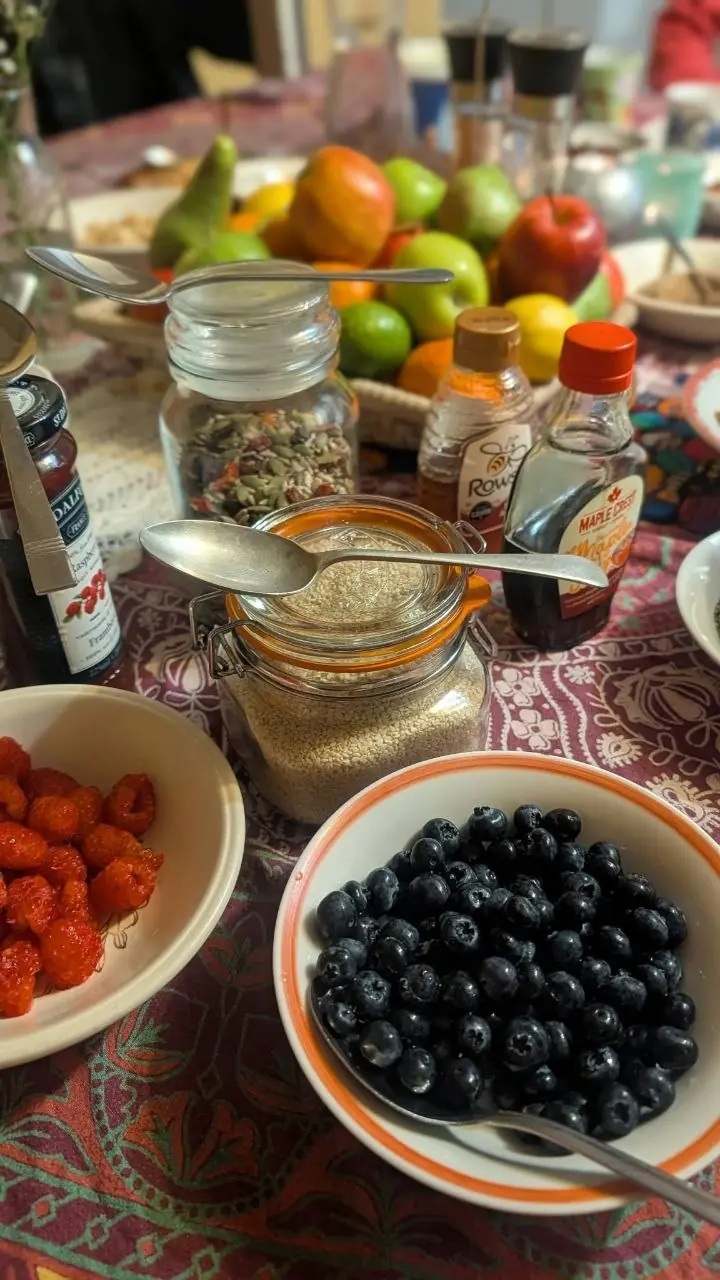 A breakfast spread of blueberries, raspberries, fresh fruit, seeds, honey and maple syrup